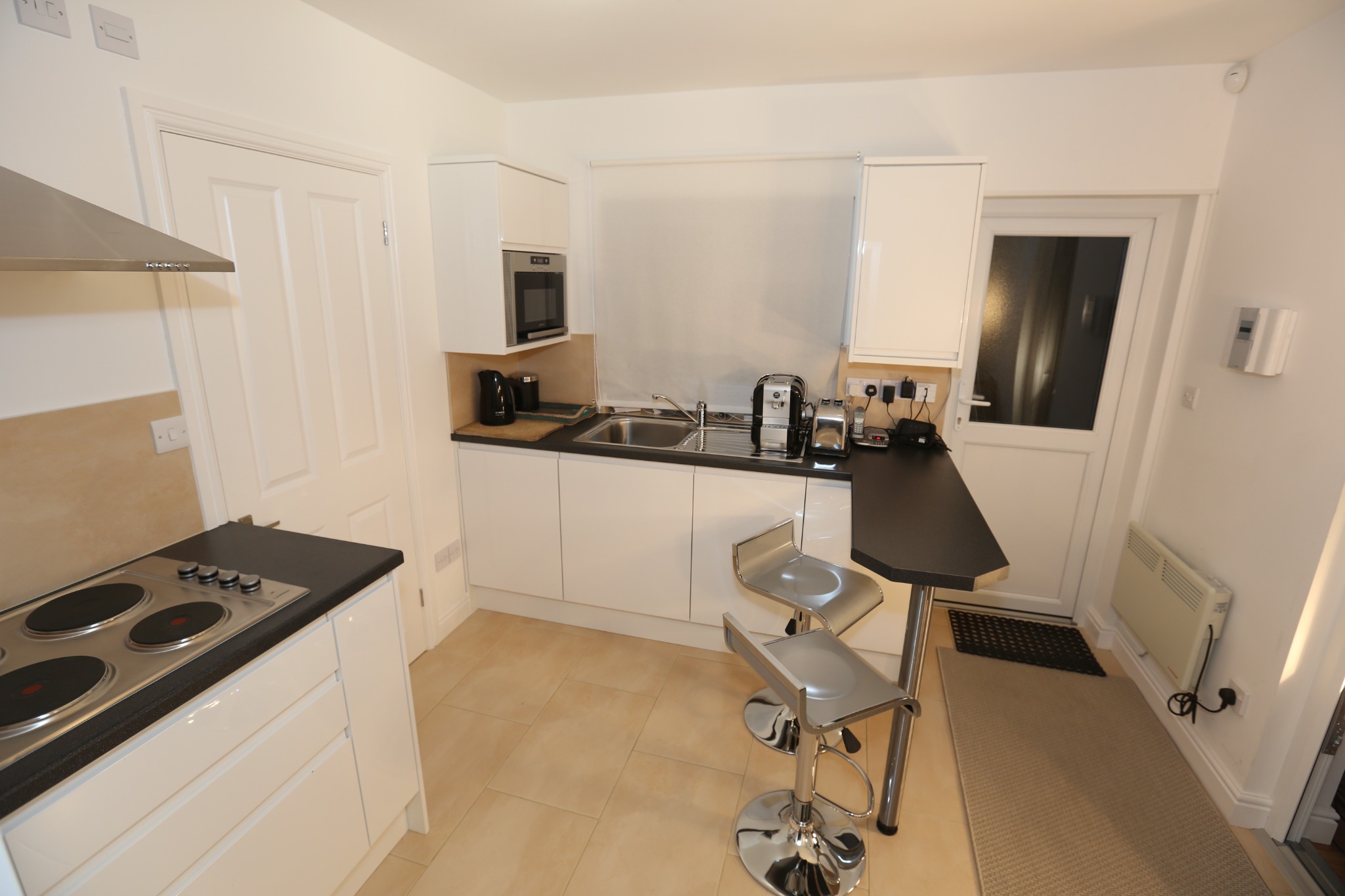 Greystoke Studio kitchen with hob, microwave, sink and seating